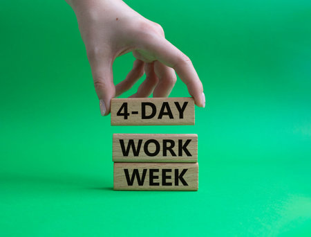 4-day work week symbol. Concept words 4-day work week on wooden blocks. Beautiful green background....