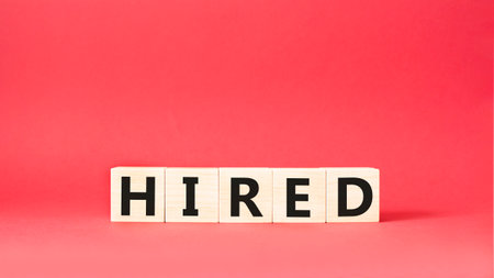 Hired symbol. Wooden cubes with word Hired. Beautiful red background. Hired concept. copyspace.の写真素材
