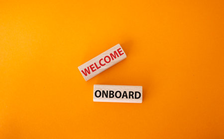 Welcome board symbol. Concept words Welcome onboard on wooden blocks. Beautiful orange background. Business and welcome board concept. copyspace.の写真素材
