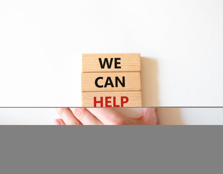 We can help you symbol. Concept words We can help you on wooden blocks. Beautiful white background. businessman hand. Business and We can help you concept. copy spaceの写真素材