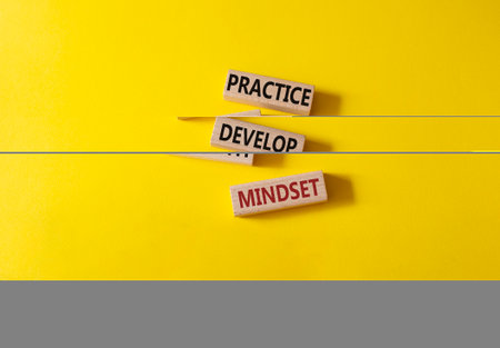 Practice and Develop growth mindset symbol. Wooden blocks with words Practice and Develop growth mindset. Beautiful yellow background. business concept. copy spaceの写真素材