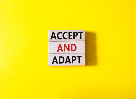 Accept or adapt symbol. Wooden blocks with words Accept and adapt. beautiful yellow background. Business and Accept and adapt concept. copyspace.の写真素材