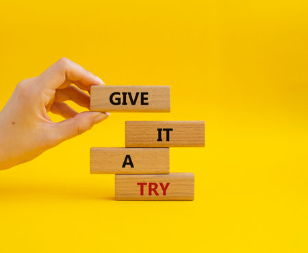 Give it a try symbol. Concept words Give it a try on wooden blocks. beautiful yellow background. businessman hand. Business and Give it a try concept. copyspace.の写真素材