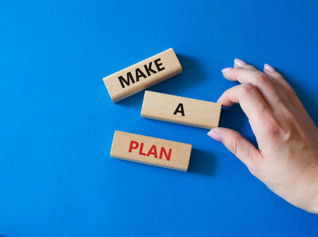 Make a plan symbol. Concept word Make a plan on wooden blocks. businessman hand. beautiful blue background. Business and Make a plan concept. copy spaceの写真素材