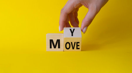 My move symbol. Businessman hand Turnes cubes with words My Move. beautiful yellow background. Business and My Move concept. copy spaceの写真素材