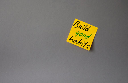 Build good habits symbol. Concept words Build good habits on orange steaky note. Beautiful gray...