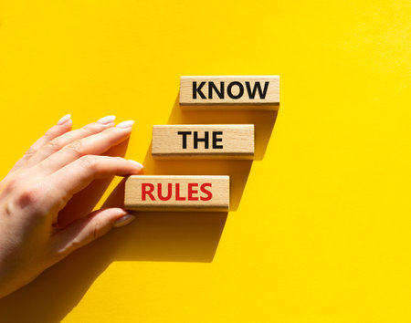 Know the rules symbol. Wooden blocks with words Know the rules. beautiful yellow background. businessman hand. Business and Know the rules concept. copyspace.の写真素材