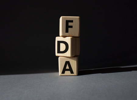FDA - Food Drug Administration symbol. Wooden cubes with word FDA. Beautiful gray background. Medical and Food Drug Administration concept. copyspace.の写真素材