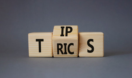 Tips and Tricks symbol. Turned wooden cubes with words Tricks and Tips. Beautiful gray background. Business and Tips and Tricks concept. copy spaceの写真素材