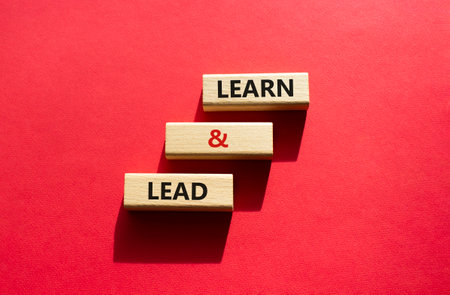 Learn and lead symbol. Concept words Learn and lead on wooden blocks. Beautiful red background. Business and Learn and lead concept. copyspace.の写真素材