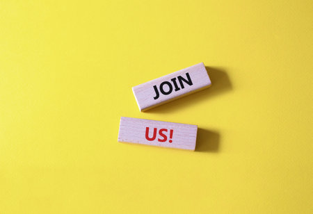 Join us symbol. Concept word Join us on wooden blocks. Beautiful yellow background. Business and Join us concept. copy spaceの写真素材