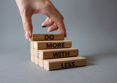 Do more with less symbol. Concept words Do more with less on wooden blocks. Beautiful gray background. businessman hand. Business and Do more with less concept. copyspace.の写真素材