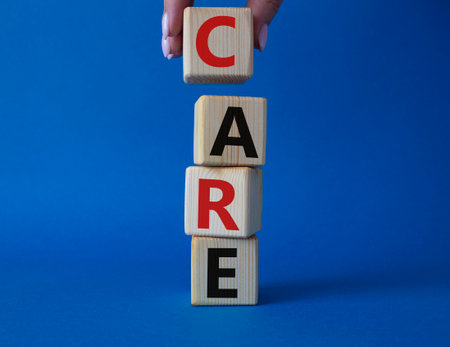 care symbol. Concept word Care on wooden cubes. businessman hand. beautiful blue background. Business and care concept. copyspace.の写真素材
