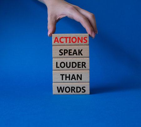 Actions speak louder than Words symbol. Wooden blocks with words Actions speak louder than Words....