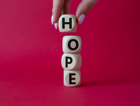 hope symbol. Concept word Hope on wooden cubes. businessman hand. Beautiful red background. Business and hope concept. copyspace.の写真素材