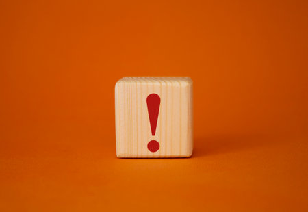 Exclamation mark symbol. Exclamation mark on wooden cubes. Beautiful orange background. Business and Exclamation mark concept. copyspace.の写真素材