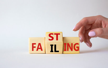 Fasting vs Failing symbol. Businessman hand points at wooden cubes with words Failing and Fasting. Beautiful white background. Fasting vs Failing and business concept. copy spaceの写真素材