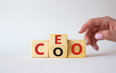 CEO and COO symbol. Businessman hand turns wooden cubes and changes word CEO to COO. Beautiful white background. CEO and COO and business concept. copy spaceの写真素材