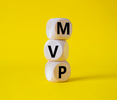 MVP - Most Valuable Player symbol. Wooden cubes with words MVP. beautiful yellow background. Business and MVP concept. copyspace.の写真素材