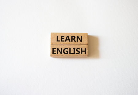 Learn English symbol. Wooden blocks with words Learn English. Beautiful white background. Business and Learn English concept. copyspace.の写真素材