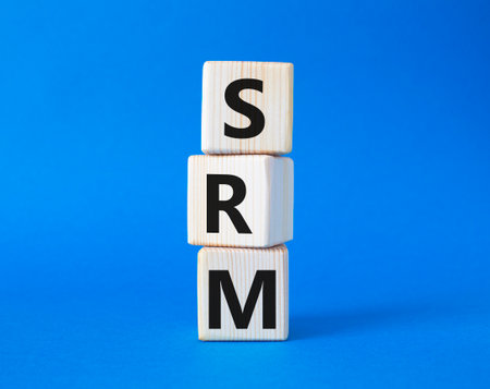 SRM - Sustainability Risk Management symbol. Wooden cubes with word SRM. beautiful blue background. Business and Finance and SRM concept. copyspace.の写真素材