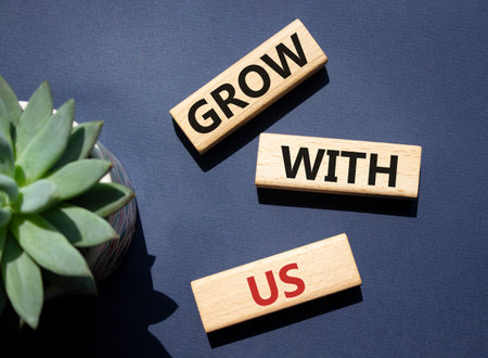 Grow with us symbol. Wooden blocks with words Grow with us. Beautiful deep blue background. Business and Grow with us concept. copyspace.の写真素材