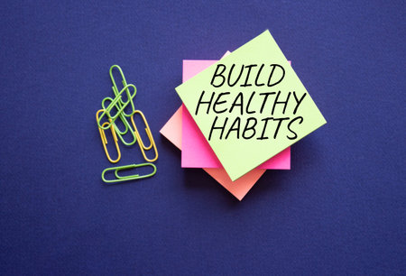 Health habits symbol. Concept word Build Healthy habits on yellow stealy note with paper clips....