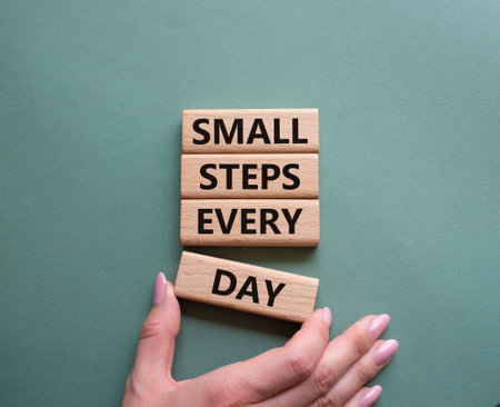Small Steps Every Day symbol. Wooden blocks with words Small Steps Every Day. Beautiful gray green background. businessman hand. Business and Small Steps Every Day concept. copyspace.の写真素材