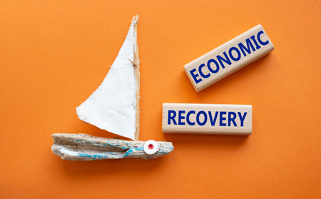 economic recovery symbol. Concept words Economic recovery on wooden blocks. Beautiful orange...