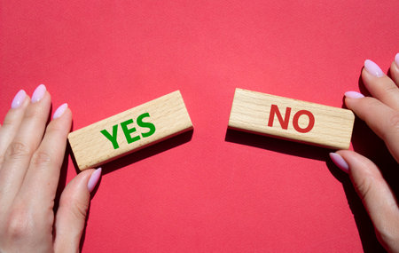 Yes or No symbol. Concept word Yes or No on wooden blocks. businessman hand. Beautiful red...