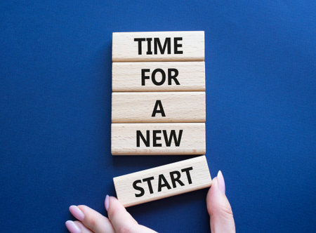Time for a new start symbol. Wooden blocks with words Time for a new start. Beautiful deep blue...