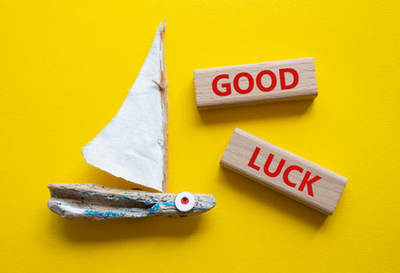 Good luck symbol. Wooden blocks with words Good luck. Beautiful yellow background with boat. Business and Good luck concept. Copy space.の写真素材