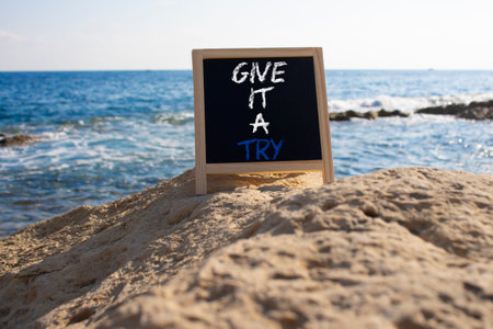 Give it a try symbol. Concept words Give it a try on chalk blackboard. Beautiful sea background. Business and Give it a try concept. Copy space.の写真素材