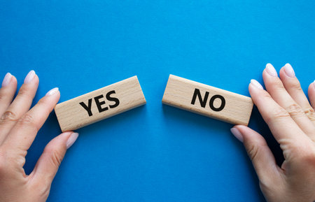 Yes or No symbol. Concept word Yes or No on wooden blocks. Businessman hand. Beautiful blue...