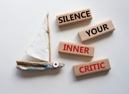 Silence your inner critic symbol. Wooden blocks with words Silence your inner critic. Beautiful...
