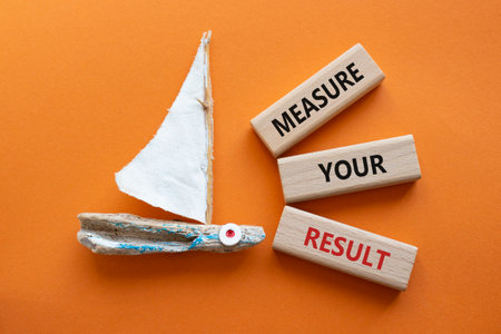 Measure your Result symbol. Concept words Measure your Result on wooden blocks. Beautiful orange background with boat. Business and Measure your Result concept. Copy space.の写真素材