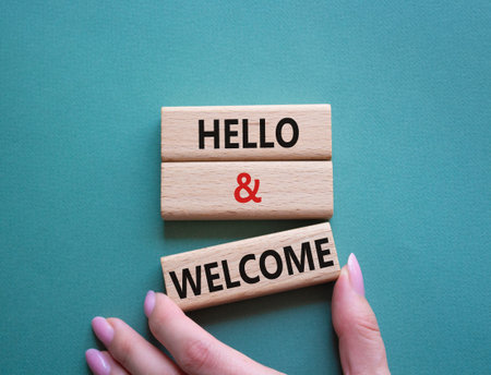 Hello and Welcome symbol. Concept words Hello and Welcome on wooden blocks. Beautiful gray green...