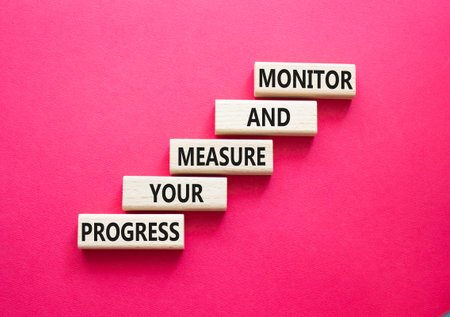 Monitor and Measure your Progress symbol. Wooden blocks with words Monitor and Measure your...