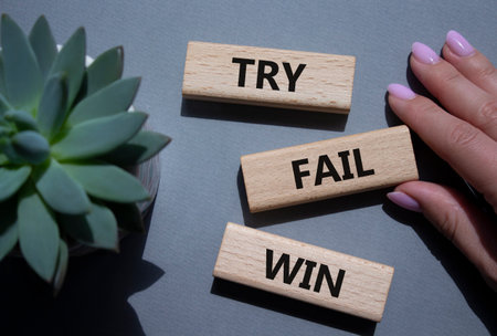 Try Fail Win symbol. Concept words Try Fail Win on wooden blocks. Beautiful gray background with succulent plant. Businessman hand. Business and Try Fail Win concept. Copy space.の写真素材