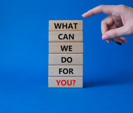 What can We do for you symbol. Wooden blocks with words What can We do for you. Beautiful blue background. Businessman hand. Business and What can We do for you. Copy space.の写真素材