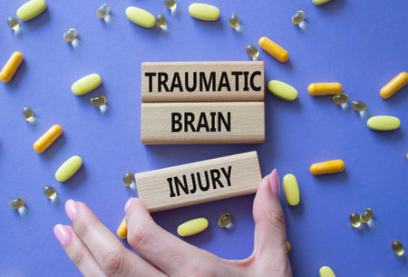 Traumatic Brain Injury symbol. Concept words Traumatic Brain Injury on wooden blocks. Beautiful purple background with pills. Doctor hand. Healthcare and Traumatic Brain Injury concept. Copy space.の写真素材
