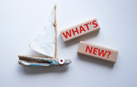 What is new symbol. Concept word What is new on wooden blocks. Beautiful white background with boat. Business and What is new concept. Copy spaceの写真素材