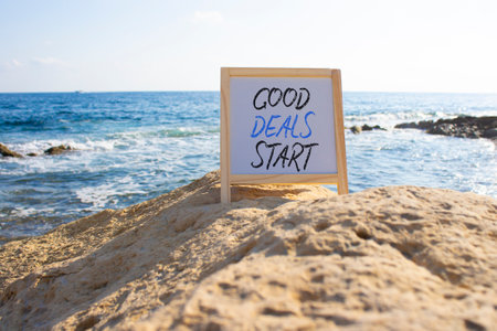 Good Deals Start symbol. White Blackboard with words Good Deals Start. Beautiful sea background. Business and Good Deals Start concept. Copy space.の写真素材