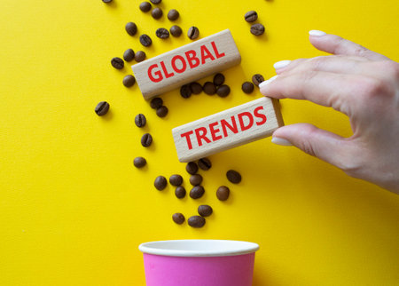 Global Trends symbol. Concept word Global Trends on wooden blocks. Beautiful yellow background with...