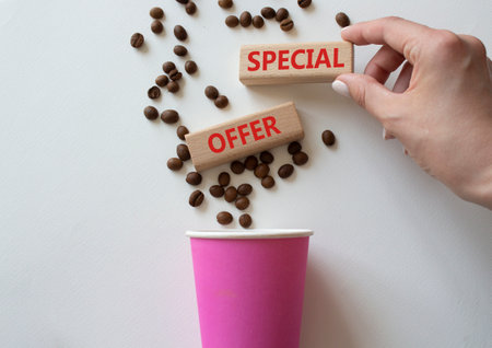Special offer symbol. Concept word Special offer on wooden blocks. Businessman hand. Beautiful white background with coffee cup. Business and Special offer concept. Copy spaceの写真素材