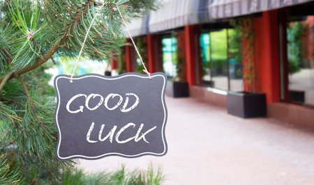 Good luck symbol. Good luck black chalk blackboard. Beautiful background with shop and tree. Business and Good luck concept. Copy space.の写真素材