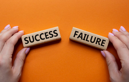 Success or Failure symbol. Concept word Success or Failure on wooden blocks. Businessman hand. Beautiful orange background. Business and Success or Failure concept. Copy spaceの写真素材