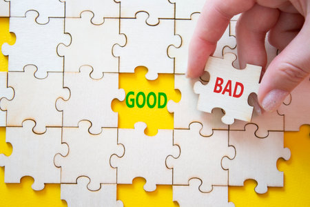 Good or Bad symbol. Concept word Good or Bad on wooden puzzle. Businessman hand. Beautiful yellow background. Business and Good or Bad concept. Copy spaceの写真素材