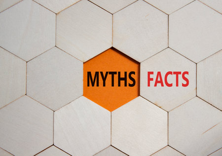 Facts or Myths symbol. Concept word Facts or Myths on wooden comb puzzle. Beautiful orange background. Business and Facts or Myths concept. Copy spaceの写真素材