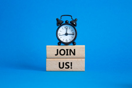 Join us symbol. Concept word Join us on wooden blocks. Beautiful blue background with alarm clock. Business and Join us concept. Copy spaceの写真素材